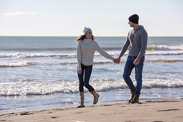 Image showing Loving young couple on a beach at autumn sunny day