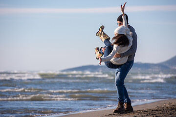 Image showing Loving young couple on a beach at autumn sunny day