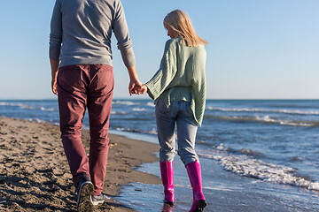 Image showing Loving young couple on a beach at autumn sunny day