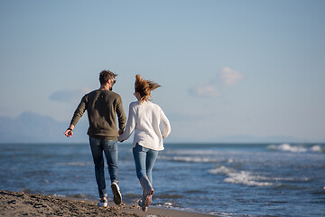 Image showing Loving young couple on a beach at autumn sunny day