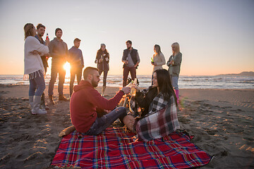 Image showing Couple enjoying with friends at sunset on the beach