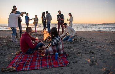 Image showing Couple enjoying with friends at sunset on the beach