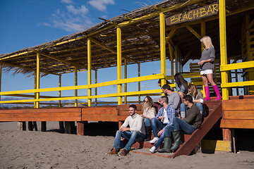 Image showing Group of friends having fun on autumn day at beach