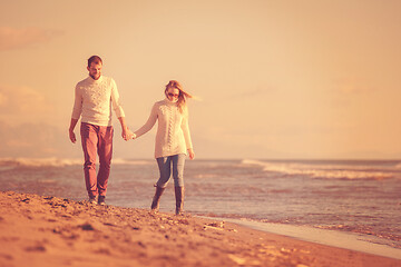 Image showing Loving young couple on a beach at autumn sunny day