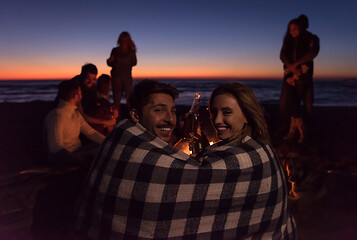 Image showing Couple enjoying with friends at sunset on the beach