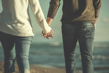 Image showing Loving young couple on a beach at autumn sunny day