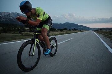 Image showing triathlon athlete riding bike at night