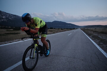 Image showing triathlon athlete riding bike at night