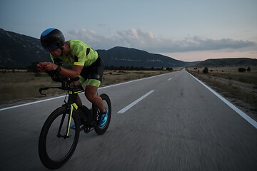 Image showing triathlon athlete riding bike at night