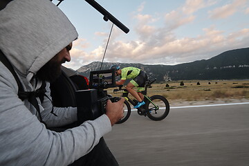 Image showing cinematographer taking action shot of triathlon bike athlete