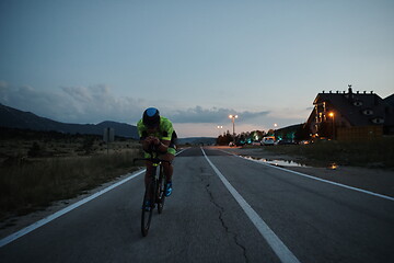 Image showing triathlon athlete riding bike at night