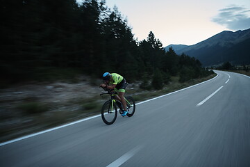 Image showing triathlon athlete riding bike at night