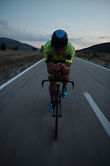 Image showing triathlon athlete riding bike at night