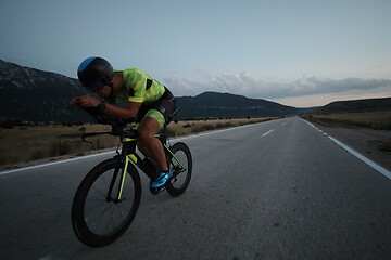 Image showing triathlon athlete riding bike at night