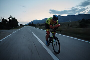 Image showing triathlon athlete riding bike at night