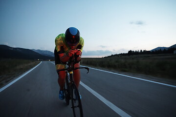 Image showing triathlon athlete riding bike at night