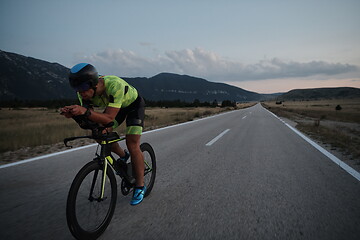 Image showing triathlon athlete riding bike at night