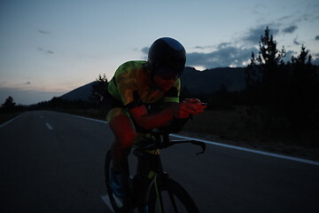 Image showing triathlon athlete riding bike at night