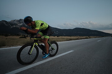 Image showing triathlon athlete riding bike at night