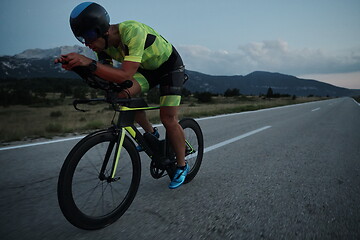 Image showing triathlon athlete riding bike at night