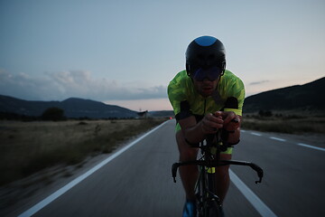 Image showing triathlon athlete riding bike at night