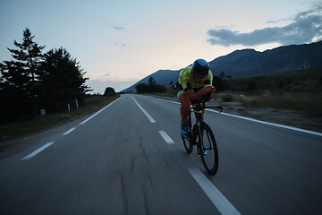 Image showing triathlon athlete riding bike at night