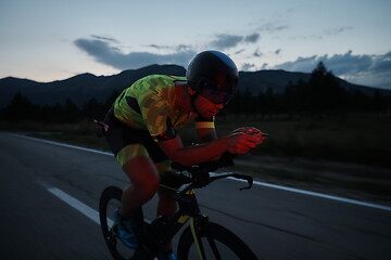 Image showing triathlon athlete riding bike at night