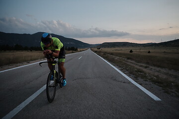 Image showing triathlon athlete riding bike at night