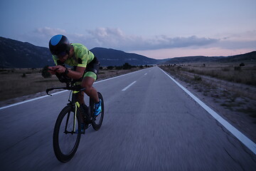 Image showing triathlon athlete riding bike at night