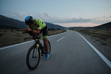 Image showing triathlon athlete riding bike at night