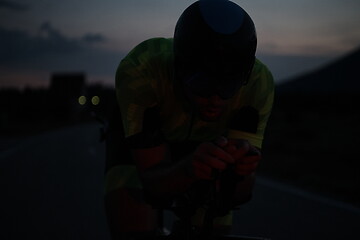 Image showing triathlon athlete riding bike at night