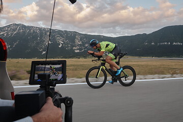 Image showing cinematographer taking action shot of triathlon bike athlete