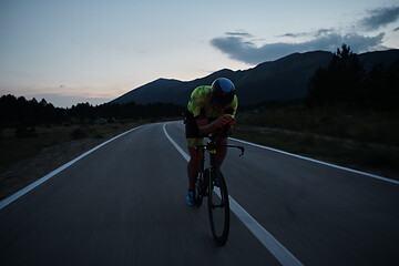 Image showing triathlon athlete riding bike at night