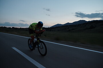 Image showing triathlon athlete riding bike at night