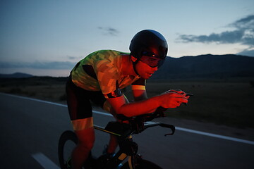 Image showing triathlon athlete riding bike at night