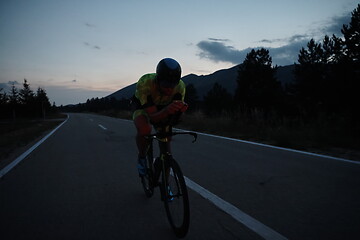 Image showing triathlon athlete riding bike at night