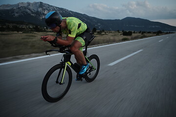 Image showing triathlon athlete riding bike at night