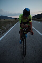 Image showing triathlon athlete riding bike at night