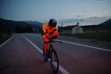 Image showing triathlon athlete riding bike at night