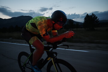 Image showing triathlon athlete riding bike at night