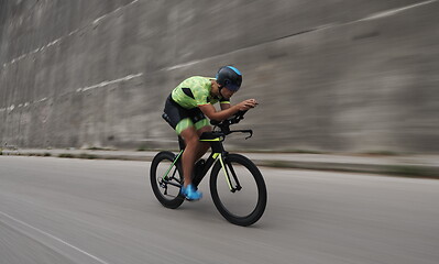 Image showing triathlon athlete riding a bike on morning training