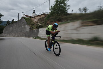 Image showing triathlon athlete riding a bike on morning training