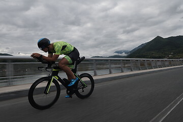 Image showing triathlon athlete riding a bike on morning training