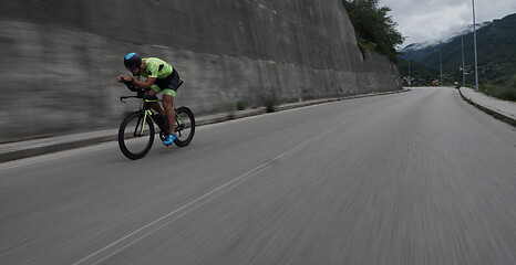 Image showing triathlon athlete riding a bike on morning training