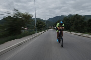 Image showing triathlon athlete riding a bike on morning training