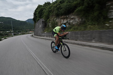 Image showing triathlon athlete riding a bike on morning training