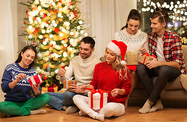 Image showing friends celebrating christmas and opening presents