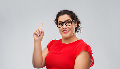 Image showing happy woman in glasses pointing finger up