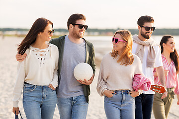 Image showing happy friends walking along summer beach