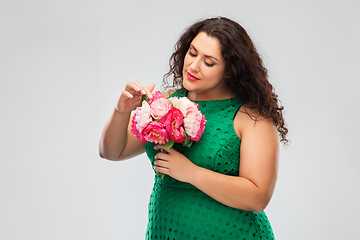 Image showing happy woman in green dress with flower bunch